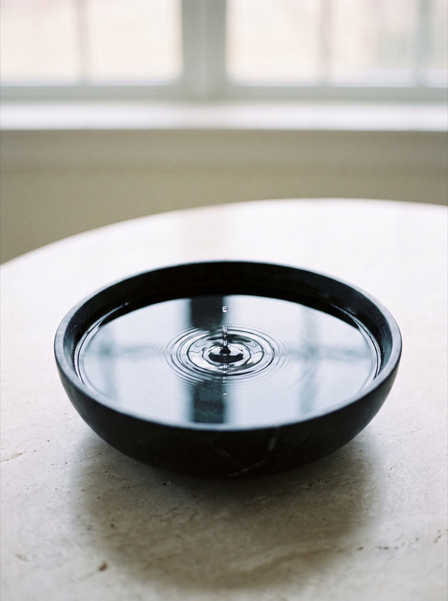 Still water in a black stone bowl